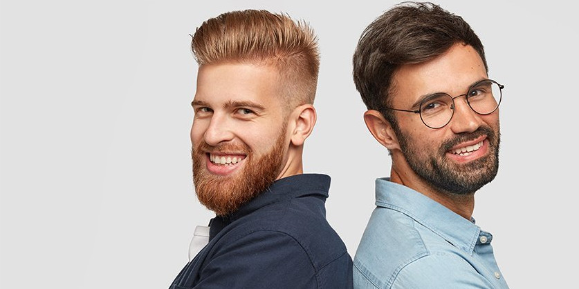 Gemeinsam eine Praxis "stemmen" Zwei lächende junge Männer stehen Rücken an Rücken