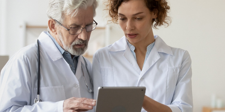 Job-Sharing Modell Zwei Ärzte schauen in ein Tablet