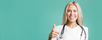 Facharztrüfung/-anerkennung Junge Ärztin hebt den Daumen nach oben