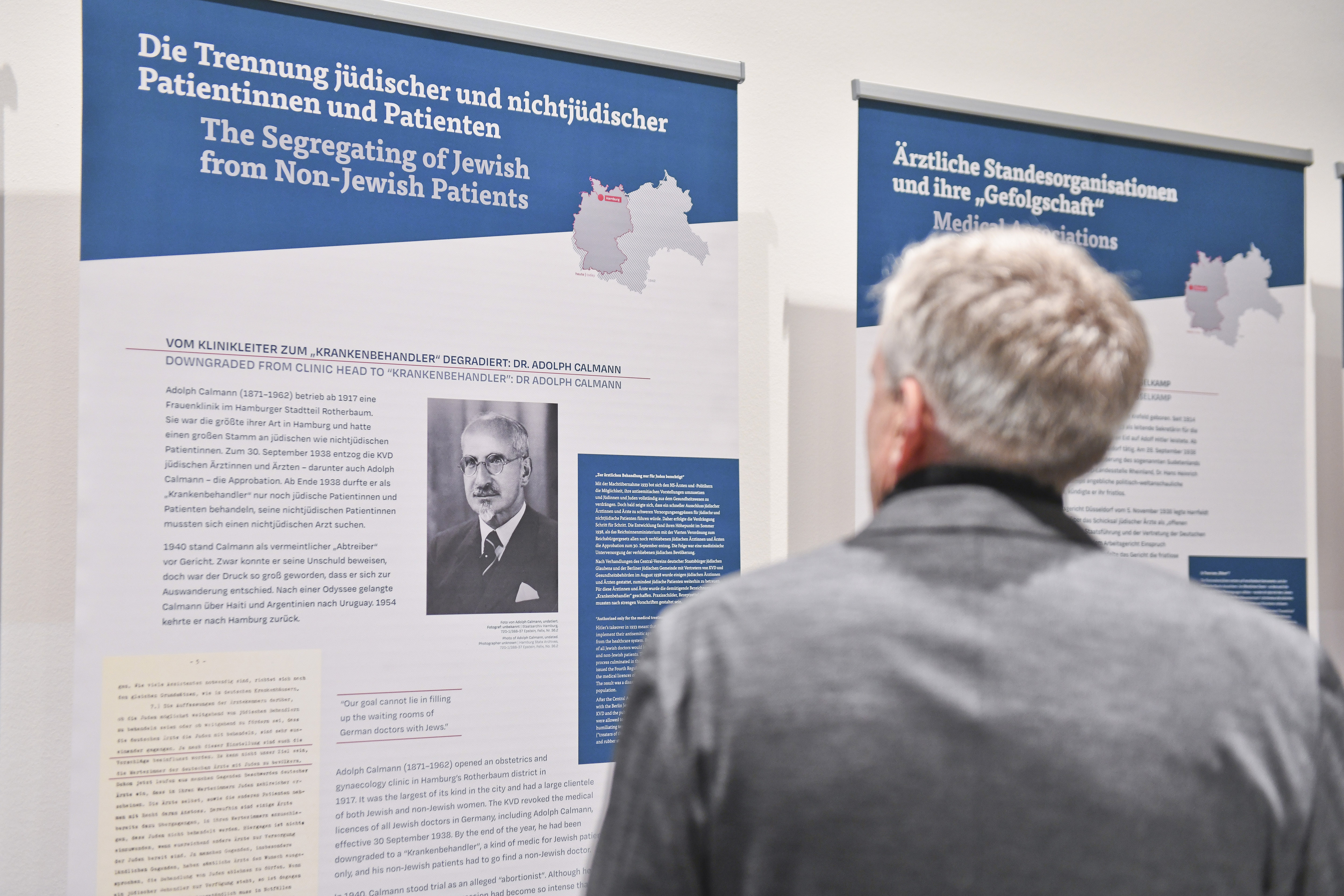 Männliche Person betrachtet ein Ausstellungsplakat