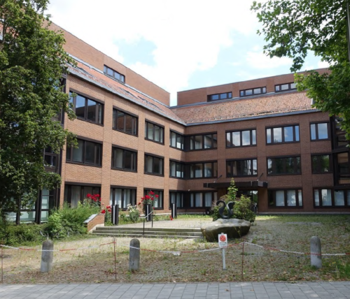 Zweiflügeliger Gebäudekomplex mit gepflastertem Vorhof